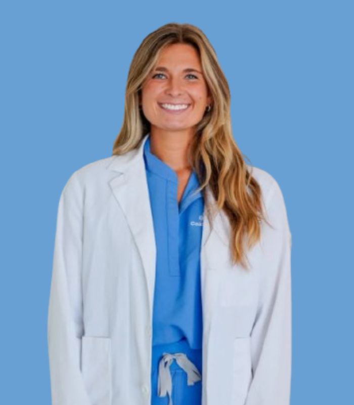 Untitled design-2 Dr. Paige Olsen in blue scrubs and a white lab coat.